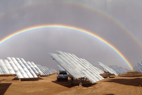 solar panels with rainbow in back, sustainable energy